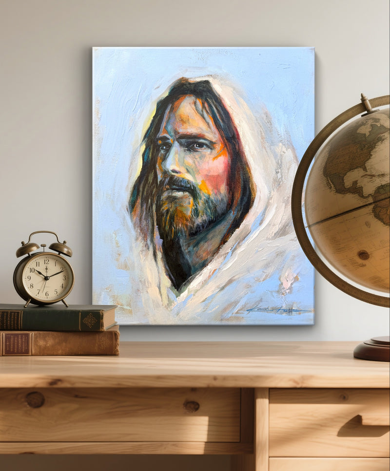 A Christian painting of Jesus with a beard in a white robe on a wall above a wooden desk for men.