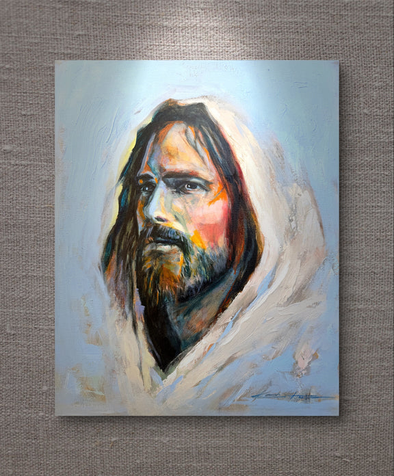 Christian painting of jesus with a white hood painted with thick paint full of texture painted with vibrancy and love, the print is laying on a textured natural cloth fabric. 