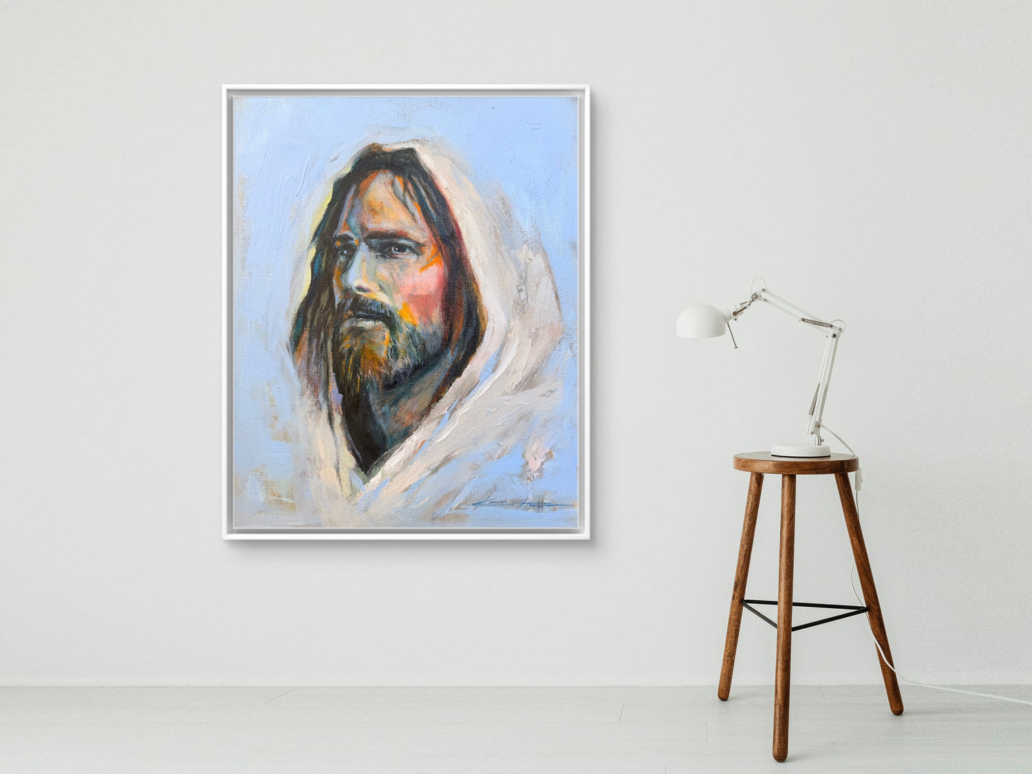 White Framed Original Oil Painting, a portrait of Jesus in periwinkle blue with big brushstrokes and thick paint, a lot of texture and vibrant colors with a lamp that is sitting on a stool. 